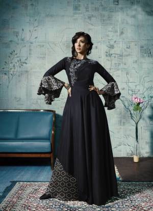 Enhance Your Personality Wearing This Designer Floor Length Gown In Navy Blue Color Fabricated Maslin With Attractive Bell Sleeve Pattern And Embroidery.