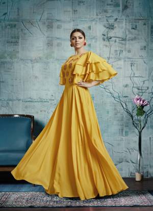 Celebrate This Festive Season Wearing This Designer Floor Length Gown In Yellow Color Fabricated On Maslin Silk. It Is Beautified With Attractive Embroidery Over The Yoke And Frill Patterned Sleeves. 