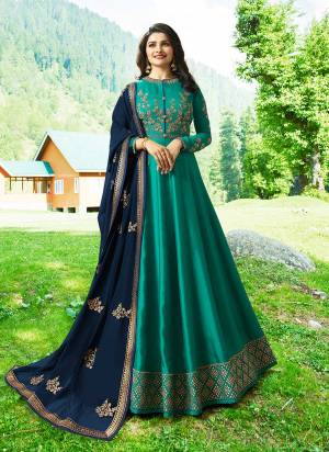 Here Is a New Beautiful Shade In Blue With This Designer Floor Length Suit In Teal Blue Color Paired With Navy Blue Colored Dupatta. Its Top Is Silk Fabricated Paired With Santoon Bottom And Chiffon Dupatta. It Has Heavy Embroidery Which Will Earn You Lots Of Compliments From Onlookers.