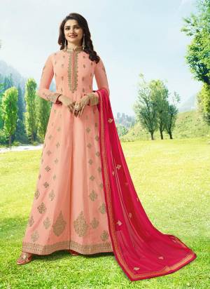 Look Pretty In This Heavy Designer Floor Length Suit In Light Peach Color Paired With Light Peach Colored Bottom And Contrasting Dark Pink Dupatta. Its Top Is Silk Based Paired With Santoon Bottom And Chiffon Dupatta. Buy Now.
