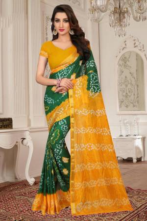 Celebrate This Festive Season Wearing This Lovely Saree In Green And Yellow Color Paired With Yellow Colored Blouse. This Saree Is Fabricated On Tafeta Silk Paired With Art Silk Blouse Beautified With Bandhani Prints all Over.