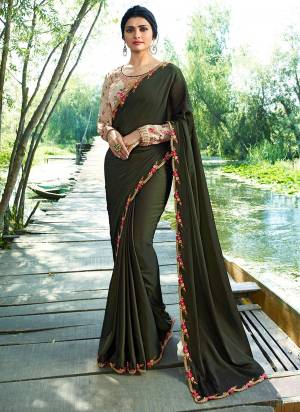 Get Ready For The Upcoming Festive And Wedding Season With This Designer Saree In Dark Olive Green Color Paired With Cream Colored Blouse. This Saree Is Fabricated On Soft Silk Paired With Silk Based Printed Blouse. Buy Now.
