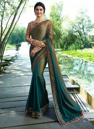 You Will Definitely Earn Lots Of Compliments Wearing This Designer Saree In Olive And Teal Green Color Paired With Contrasting Dusty Pink Colored Blouse. This Saree Is Soft Silk Based Paired with Sparkle Silk Fabricated Blouse. It Has Lovely Floral Prints With Heavy Embroidery Work.