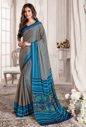 For Your Casual Or Semi-Casual Wear, Grab This Saree In Dark Grey And Blue Color Paired With Blue Colored Blouse. This Saree And Blouse Are Georgette Based Beautified With Intricate Prints All Over It.
