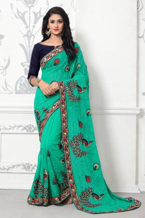 Here Is A Beautiful and Attractive Sea Green Colored Saree Paired With Contrasting Navy Blue Colored Blouse. This Saree IS Fabricated On Georgette Paired With Art Silk Fabricated Blouse. It Is Beautified With Peacock Motif Embroidery.