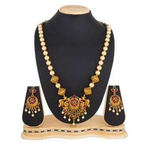 For An elegant And Simple Look, Grab This Pretty Necklace Set In Golden Color Beautified With Green And Pink Colored Stone Work, It Can Be Paired With Any Contrasting Ethnic Attire.