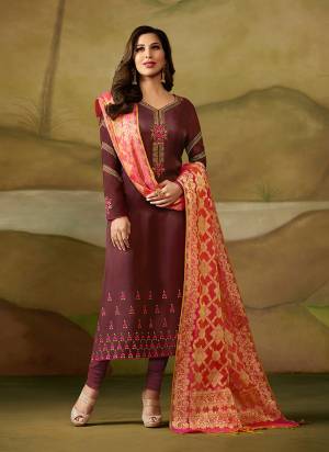Add This New Color Pallete To Your Wardrobe With This Designer Straight Suit In Wine Color Paired With Contrasting Orange Colored Dupatta. Its Top Is Fabricated On Satin Georgette Paired With Santoon Bottom And Banarasi Silk Dupatta. It Is Beautfied With Attractive Embroidery Over Its Top.