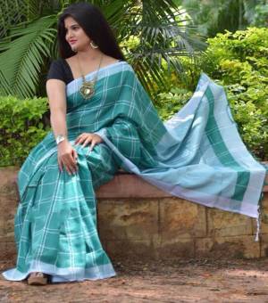 Grab This Pretty Saree In Turquoise Blue Color Paired With Black Colored Blouse. This Saree And Blouse Are Fabricated On Cotton Linen Beautified With Checks Prints all Over. 