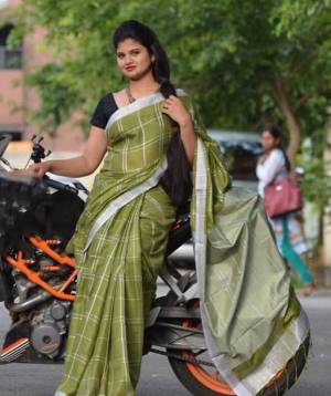 Grab This Pretty Saree In Olive Green Color Paired With Black Colored Blouse. This Saree And Blouse Are Fabricated On Cotton Linen Beautified With Checks Prints all Over. 