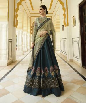 Grab This Designer Lehenga Choli With Lovely Color Pallete In Pastel Green Colored Blouse And Dupatta Paired With Peacock Blue Colored Lehenga. This Lehenga And Choli Are Silk Based Paired With Net Fabricated Dupatta. Its Attractive Embroidery And Fabric Will Earn You Lots Of Compliments From Onlookers.