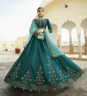 Go With This New Shades Of Blue With This Heavy Designer Lehenga Choli In Teal Blue Color Paired With Aqua Blue Colored Dupatta. This Lehenga Choli Is Silk Based Paired With Net Dupatta. It Has Heavy Embroidery Making The Lehenga Attractive.