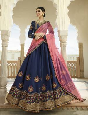 Enhance Your Personality Wearing This Heavy Designer Lehenga Choli In Navy Blue Color Paired With Contrasting Pink Colored Dupatta. Its Blouse And Lehenga Are Silk Based Paired With Net Fabricated Dupatta. It Has Contrasting Embroidery Over The Lehenga And Blouse. 