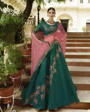 New And Unique Shade In Green Is Here With This Heavy Designer Lehenga Choli In Pine Green Color Paired With Contrasting Pink Colored Blouse. This Lehenga Choli Is Fabricated On Velvet Silk Paired With Net Dupatta. Buy Now.