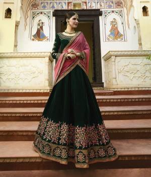 To Give A Royal Look To Your Personality, Grab This Heavy Deisgner Lehenga Choli In Dark Green Color Paired With Contrasting Pink Colored Dupatta. Its Lehenga And Choli Are Velvet Based Paired With Net Dupatta. Buy This Attractive Lehenga Choli Now.