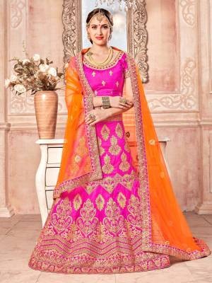 Shine Bight Wearing This Designer Lehenga Choli In Fuschia Pink Color Paired With Orange Colored Dupatta. Its Blouse And Lehenga Are Fabricated On Art Silk Paired With Net Fabricated Dupatta. It Is Beautified With Heavy Jari Embroidery And Stone Work. Buy Now.