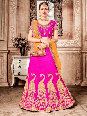 Shine Bight Wearing This Designer Lehenga Choli In Fuschia Pink Color Paired With Orange Colored Dupatta. Its Blouse And Lehenga Are Fabricated On Art Silk Paired With Net Fabricated Dupatta. It Is Beautified With Heavy Jari Embroidery And Stone Work. Buy Now.