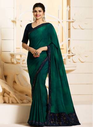 Beautiful Shade In Green Is Here With This Peacock Green Colored Saree Paired With Contrasting Navy Blue Colored Blouse. This Saree Is Georgette Based Paired With Art Silk Fabricated Blouse. It Is Beautified With Stone Work Over The Blouse And Saree. Buy Now.