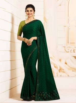 Enhance Your Personality Wearing This Designer Saree In Dark Green Color Paired With Pear Green Colored Blouse. This Saree Is Georgette Based Paired With Art Silk Fabricated Blouse. It Has Attractive Stone Work Over The Saree And Blouse.