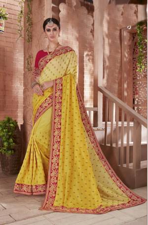 Celebrate This Festive Season Wearing This Beautiful Saree In Yellow Color Paired With Contrasting Red Colored Blouse. This Saree And Blouse Are Art Silk Based Beautified With Embroidery. 