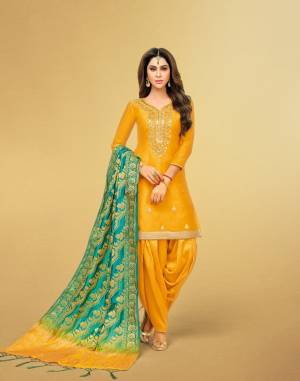 This Festive Season, Be The Outstanding Diva Wearing This Designer Patiyala Suit In Musturd Yellow Color Paired With Contrasting Turquoise Blue Colored Dupatta. Its Top Is Art Silk Based Paired With Lawn Cotton Bottom And Banarasi Art Silk Dupatta. It Is Beautified With Gota Work With Attractive Banarasi Dupatta. 