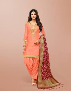 A Must Have Shade In Every Womens Wardrobe Is Here With This Designer Patiala Suit In Dark Peach Color Paired With Contrasting Maroon Colored Dupatta. Its Gota Embroidered Top IS Silk Based Paired With Lawn Cotton Bottom And Banarasi Art Silk Dupatta. 