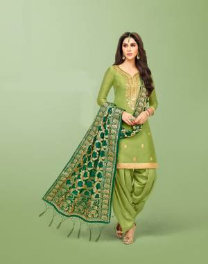 Look Beautiful In This Pretty Shade Of Green With this Light Green Colored Top And Bottom Paired With Dark Green Colored Dupatta. Its Top Is Silk Based Beautified With Gota Work Paired With Lawn Cotton Bottom And Banarasi Art Silk Dupatta. Buy Now.