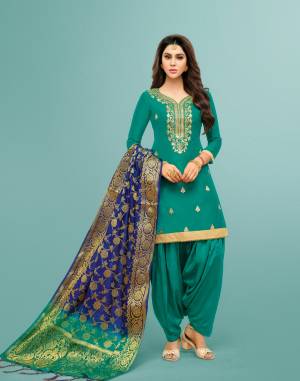New Shade In Green Is Here With This Suit In Teal Green Colored Top And Bottom Paired With Contrasting Royal Blue Colored Dupatta. Its Top Is Art Silk Based Paired With Lawn Cotton Bottom And Banarasi Dupatta. Buy Now.