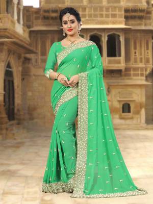 For A Festive Look, Grab This Beautiful Saree In Green Color Paired With Green Colored Blouse. This Saree And Blouse Are Georgette Based Beautified with Jari Embroidery And Moti Work Which IS Making This Saree Heavy. 