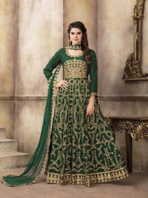 Add This Attractive Looking Heavy Designer Floor Length Suit To Your Wardrobe In Green Color Paired With Green Colored Blouse. Its Top Is Fabricated On Art Silk Paired With Santoon Bottom And Net Dupatta. It Is Beautified With Jari Embroidery And Stone Work. 