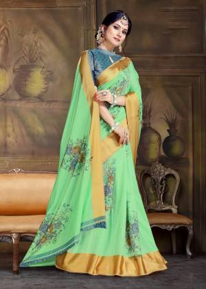 Add This Beautiful Traditional Colored Saree In Green Paired With Contrasting Blue Colored Blouse. This Saree And Blouse Are Silk Based Beautified With Bold Floral Prints. 