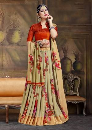 Catch All The Limelight Wearing This Designer Silk Based Saree In Light Olive Green Color Paired With Contrasting Rust Orange Colored Blouse. This Saree And Blouse Are Silk Based Beautified With Contrasting Bold Floral Prints.