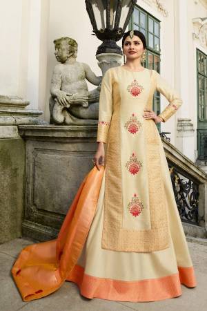 Simple And Elegant Looking Designer Floor Length Gown Is Here In Cream Color Paired With Orange Dupatta. Its Top Is Art Silk fabricated Paired With Banarasi Silk Dupatta. It Is Beautified With Multi Colored Embroidered Motifs.