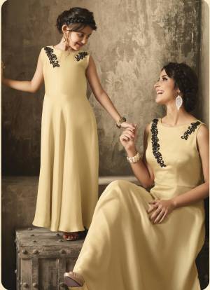 Simple And Elegant Looking Designer Floor Length Gown For Mother And Dughter Is Here In Cream Color. This Floor Length Gown Is Fabricated On Satin Beautified With Moti Work Over The Neck. Buy Now.
