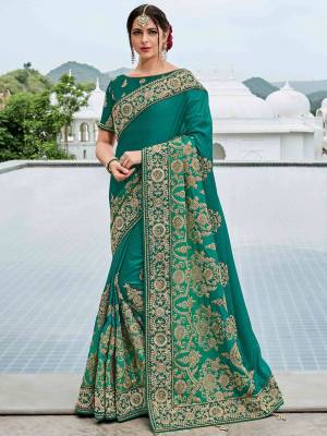 Look gorgeous in this beautiful printed Teal green color two tone shadded silk satin saree. Ideal for party, festive & social gatherings. this gorgeous saree featuring a beautiful mix of designs. Its attractive color and heavy designer embroidered saree, moti design, also heavy designer blouse, half half design saree, beautiful floral design all over work over the attire & contrast hemline adds to the look. Comes along with a contrast unstitched blouse.