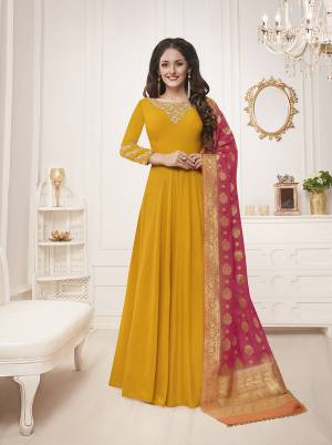 Celebrate This Festive Season With This Bright And Attractive Looking Designer Floor Length Suit In Musturd Yellow Color Paired With Contrasting Pink Colored Dupatta. Its Top Is Fabricated On Muslin Silk Paired With Santoon Bottom And Banarasi Silk Dupatta. Buy This Now.