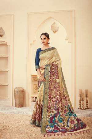 Falunt Your Rich And Elegant Taste Wearing This Silk Based Saree In Cream Color Paired With Navy Blue Colored Blouse. This Saree And Blouse are Beautified With Elegant Prints.