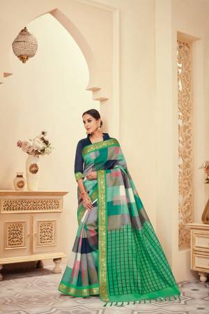 You Will Definitely Earn Lots Of Compliments Wearing This Rich Looking Saree In Green Multi Color Paired With Contrasting Navy Blue Colored Blouse. It Is Beautified With Bold Checks Prints All Over The Saree.