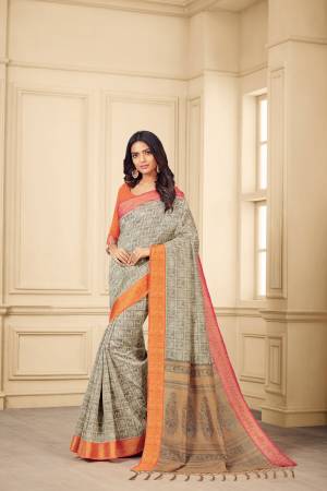 Flaunt Your Rich And Elegant Taste Wearing This Saree In Grey Color Paired With Contrasting Orange Colored Blouse. This Saree And Blouse Are Silk Based Beautified With Prints. 