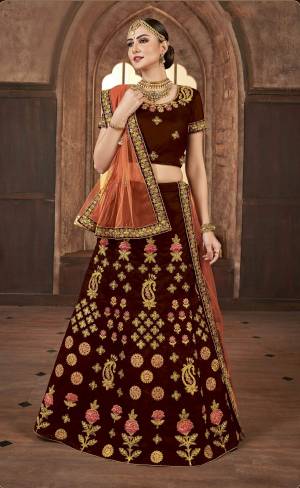 For A Royal Look, Grab This Heavy Designer Lehenga Choli In Maroon Color Paired With Contrasting Orange Colored Dupatta. Its Blouse And Lehenga Are Fabricated On Satin Silk Paired With Net Fabricated Dupatta. 