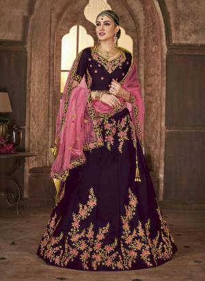 Here Is A Beautiful Shade With This Heavy Designer Lehenga Choli In Wine Color Paired With Contrasting Pink Colored Dupatta. Its Is Satin Silk Based Paired With Net Fabricated Dupatta, Buy Now.