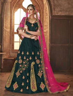 You Will Definitely Earn Lots Of Compliments Wearing This New Shade In Green With This Heavy Designer Lehenga Choli In  Pine Green Color Paired With Contrasting Rani Pink Colored Dupatta. Its Blouse And Lehenga Are Satin Silk Based Paired With Net Fabricated Dupatta. 