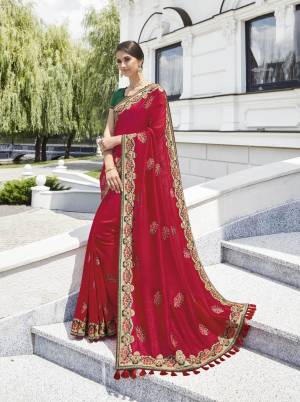 Adorn The Pretty Angelic Look Wearing This Red Colored Saree Paired With Contrasting Dark Green Colored Blouse. This Saree And Blouse Are Silk Based Beautified With Embroidered Lace Border And Motifs All Over.