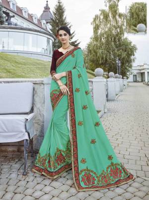 Celebrate This Festive Season with Colorful Attire Wearing This Designer Saree In Sea Green Color Paired With Contrasting Wine Colored Blouse. This Saeee Is Fabricated On Georgette Paired With Art Silk Fabricated Blouse. 