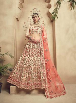 Simple And Elegant Looking Heavy Designer Lehenga Choli Is Here In Cream Color Paired With Contrasting Peach Colored Dupatta. Its Heavy Embroidered Blouse And Lehenga Are Fabricated On Silk velvet Paired With Net Dupatta. This Lehenga Choli Will Definitely Earn You Lots Of Compliments From Onlookers.