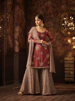Add This Very Pretty Sharara Dress In Rust Red Colored Top Paired With Mauve Colored Bottom And Dupatta. Its Top And Bottom Are Net Based Paired With Chiffon Fabricated Dupatta. Its Pretty Color Combination And Embroidery Will Earn You Lots Of Compliments From Onlookers. Buy Now.