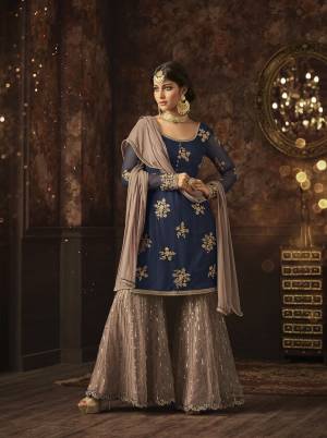 Add This Very Pretty Sharara Dress In Blue Colored Top Paired With Mauve Colored Bottom And Dupatta. Its Top And Bottom Are Net Based Paired With Chiffon Fabricated Dupatta. Its Pretty Color Combination And Embroidery Will Earn You Lots Of Compliments From Onlookers. Buy Now.