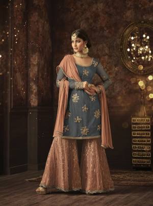 Add This Very Pretty Sharara Dress In Steel Blue Colored Top Paired With Peach Colored Bottom And Dupatta. Its Top And Bottom Are Net Based Paired With Chiffon Fabricated Dupatta. Its Pretty Color Combination And Embroidery Will Earn You Lots Of Compliments From Onlookers. Buy Now.