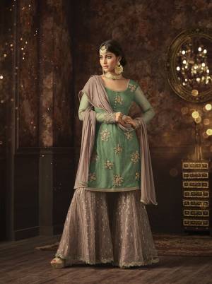 Add This Very Pretty Sharara Dress In Light Green Colored Top Paired With Mauve Colored Bottom And Dupatta. Its Top And Bottom Are Net Based Paired With Chiffon Fabricated Dupatta. Its Pretty Color Combination And Embroidery Will Earn You Lots Of Compliments From Onlookers. Buy Now.