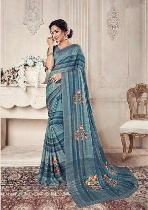 Here Is A Very Pretty Elegant Looking Shade With This Saree In Steel Blue Color Paired With Steel Blue Colored Blouse. This Saree And Blouse Are Georgette Based Beautified With Lining And Floral Prints. 