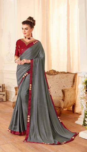 Flaunt Your Rich And Elegant Taste Wearing This Designer Saree In dark Grey Color Paired With Contrasting Maroon Colored Blouse. This Saree And Blouse Are Silk Based Beautified With Embroidery Over Blouse And Saree Lace Border. 